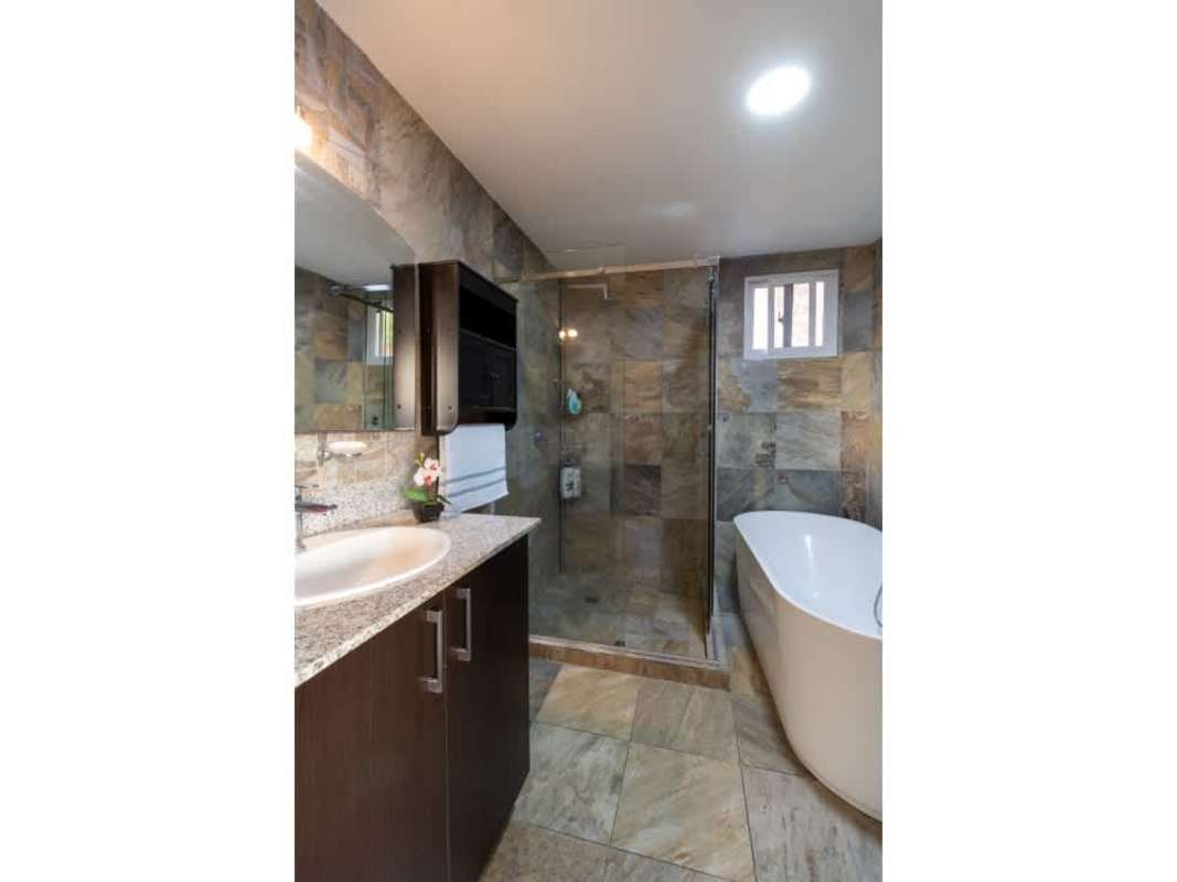 Large walk-in closet with dark wood shelves and storage in house for sale Limajos Panama City