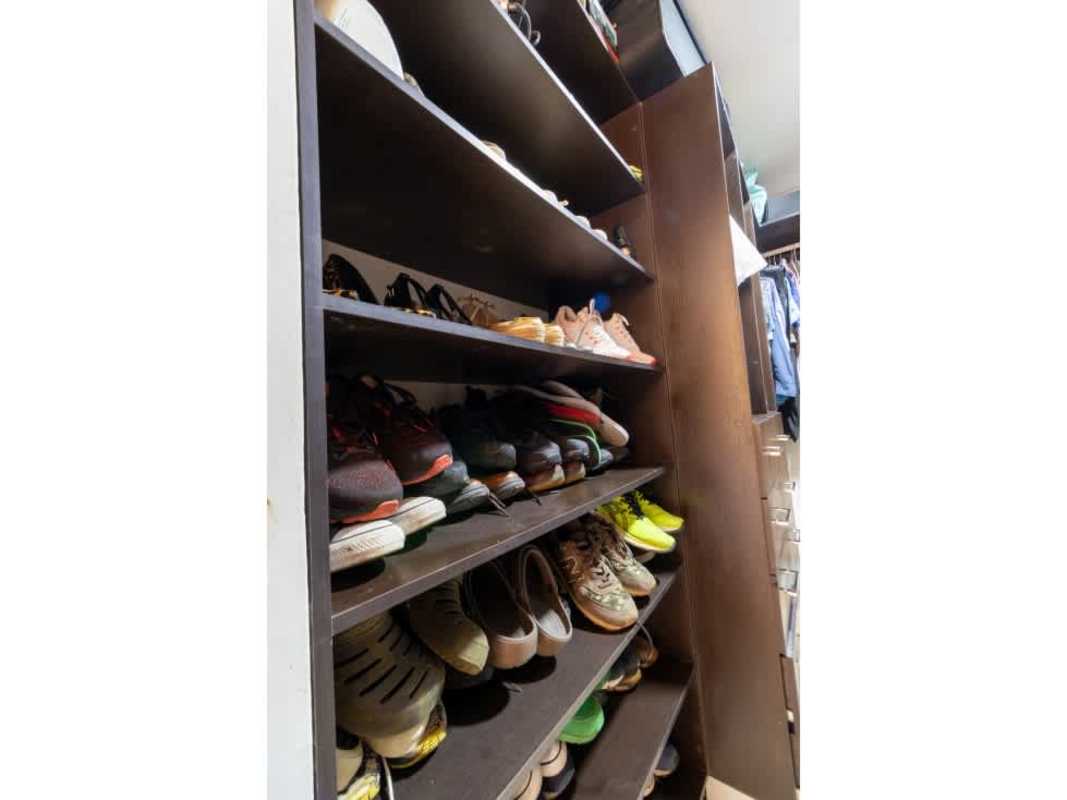 Large organized walk-in closet with built-in shoe racks in family house Limajos Panama