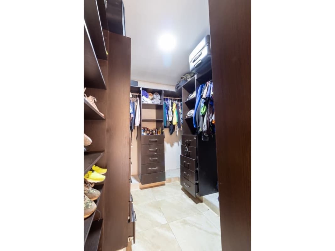 Modern walk-in closet with shoe storage and shelves in Limajos Panama City home