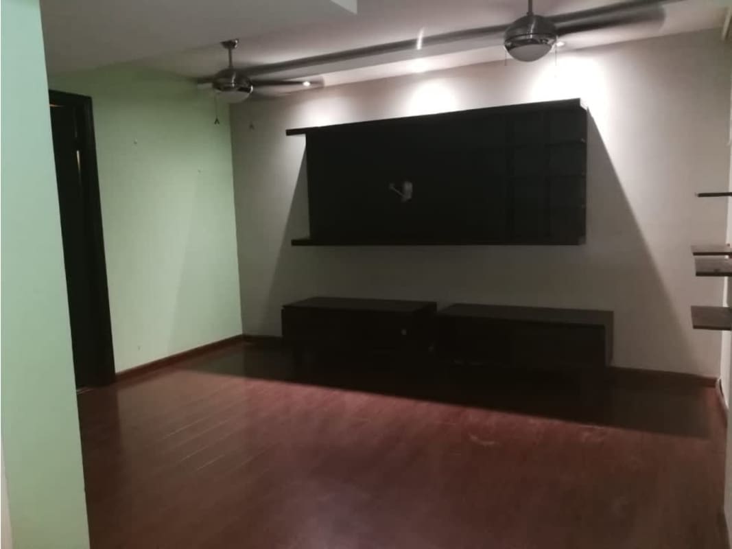 Living room with wood floors, ceiling fans, and TV console in Condado del Rey Panama house