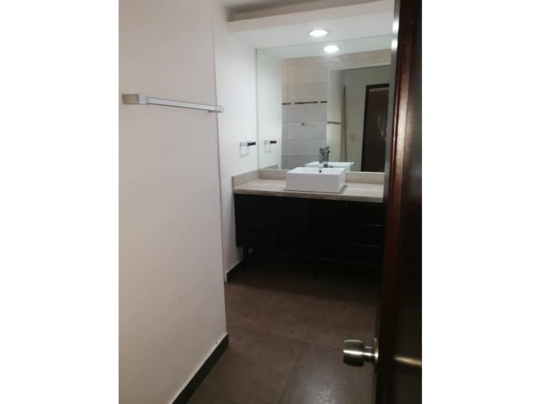 Modern bathroom with vessel sink large mirror and storage in Condado del Rey duplex house Panama City