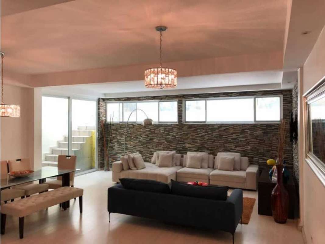 Spacious living room with stone accent wall, blue sofa, dining table in duplex house Limajos Betania Panama