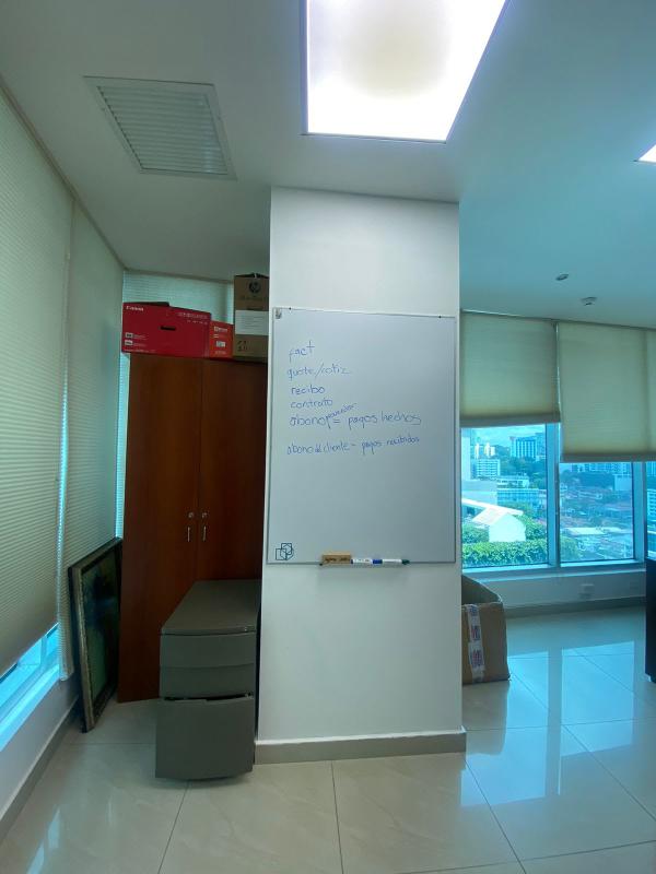 Large meeting room with clocks, TV, marble flooring, decorated walls inside Banesco Tower Panama