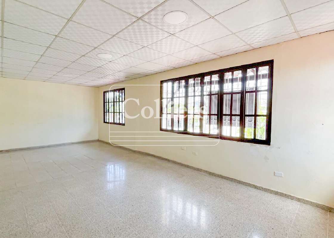 Bright office room with windows, drop ceiling, and neutral walls in commercial building