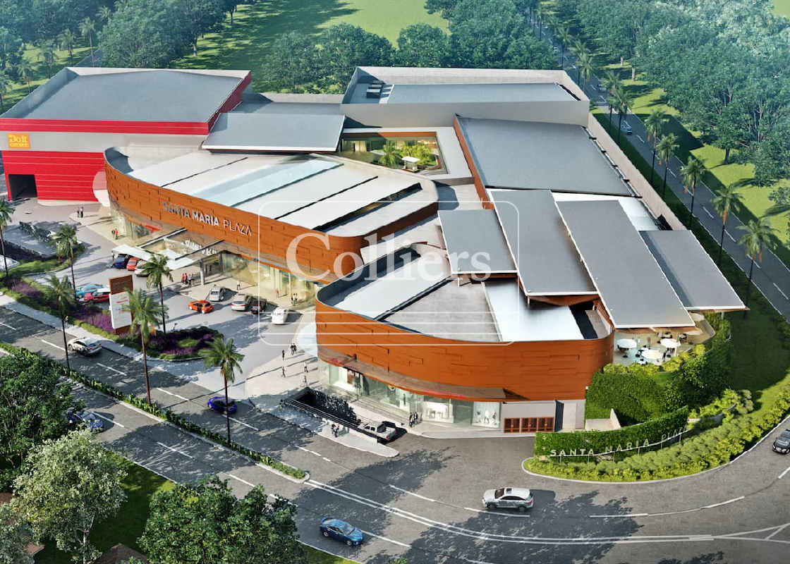 Aerial shot of spacious contemporary shopping center with multiple retail units surrounded by parking and green areas