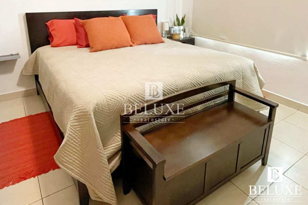 Bedroom with neutral decor featuring orange accents and ample lighting at PH Concept San Francisco Panama