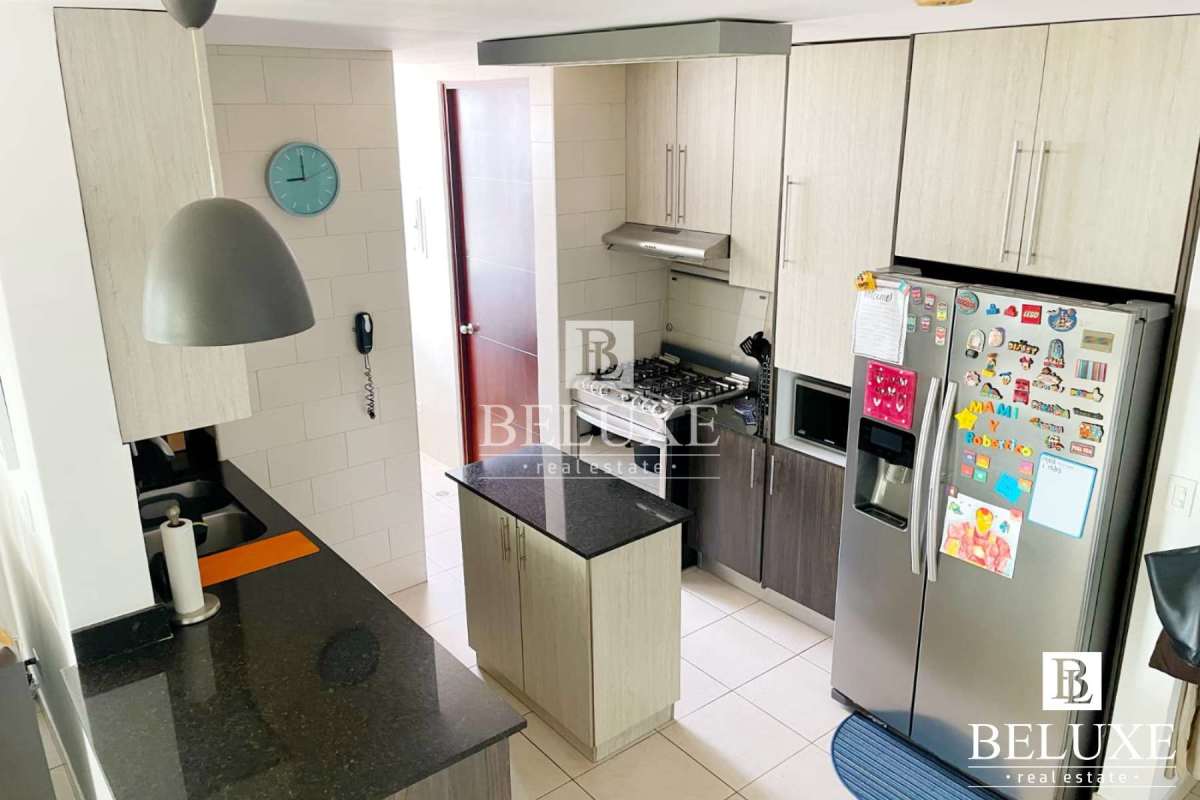 Kitchen with granite island, stainless appliances and light wood cabinetry at PH Concept San Francisco Panama