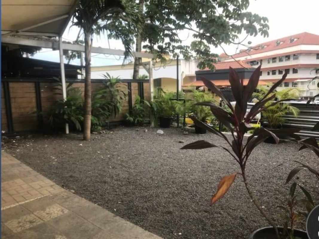 Outdoor landscaped gravel garden tropical plants wood fencing commercial space Albrook Panama