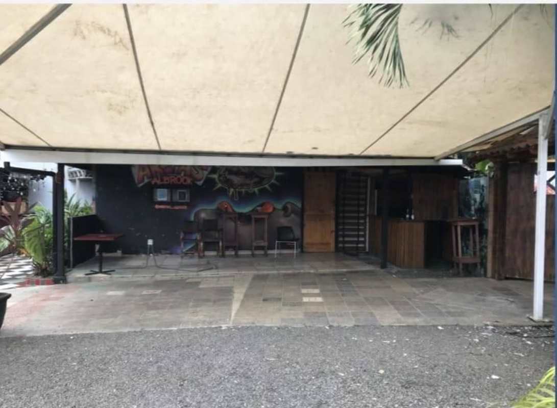 Outdoor entertainment patio with beige canopy, graffiti wall, and bar counter in commercial plaza Albrook Panama