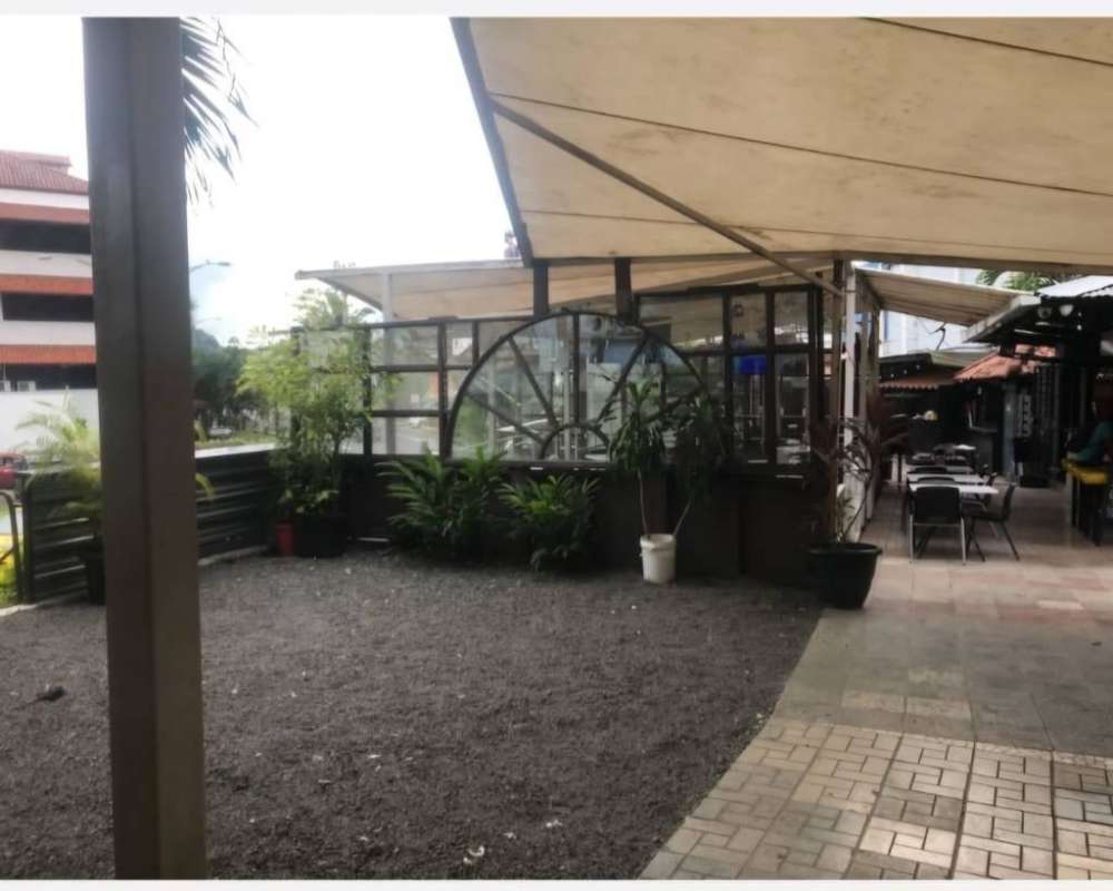 Exterior image of commercial unit with canopy shaded patio, tropical plants, mural art in Albrook Panama City
