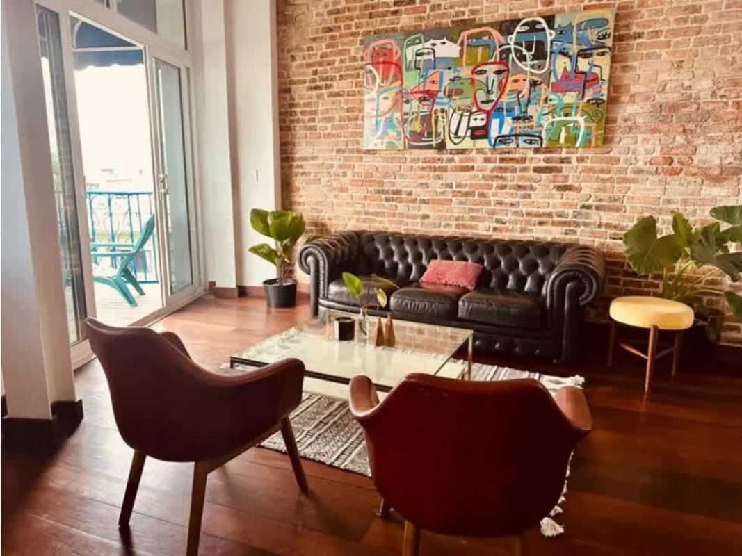 Living room with exposed brick, wood floors, and open layout Casco Viejo Panama