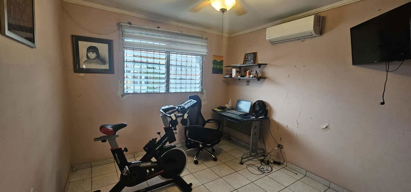 Traditional kitchen with beige cabinets, tiled walls, fridge, stove, and cooking area in house for sale Panama