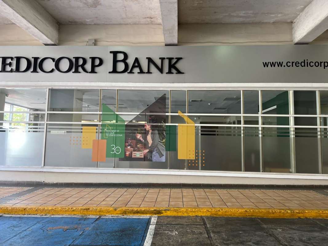 Interior reception with tiled floor, counters, glass partitions and queue barriers at bank branch space El Dorado Panama