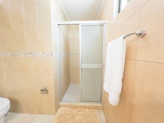 Kitchen with granite countertops, microwave, stove, and wood cabinetry in Playa Blanca Resort apartment Panama