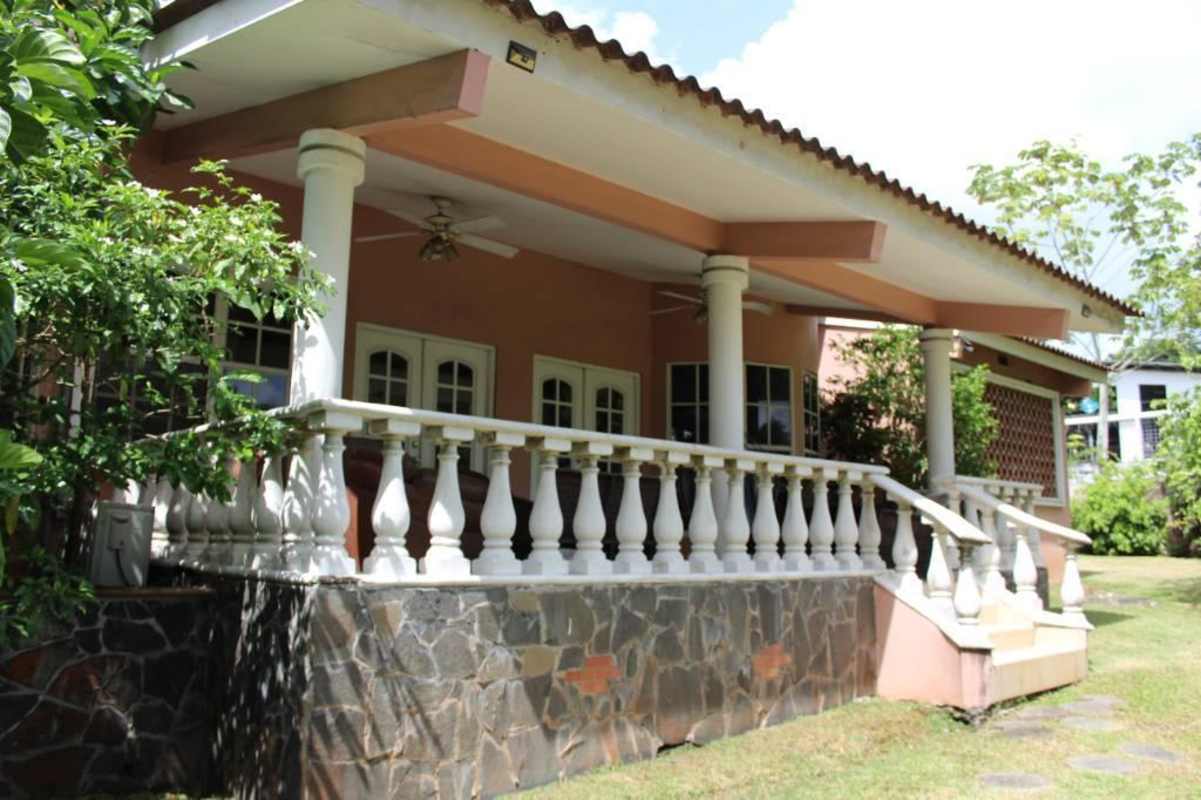 Peach-colored colonial house white columns balustrade garden porch Las Cumbres residential Panama