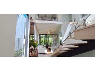 Contemporary open-plan living room with floating staircase and large windows in Explora Panama Pacifico