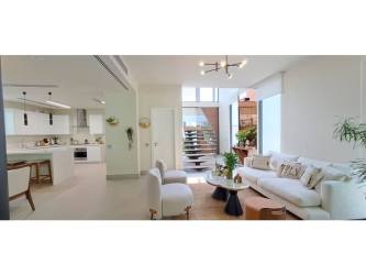 Spacious outdoor patio with green lawn, barbecue area, and lounge spaces in Explora Panama Pacifico