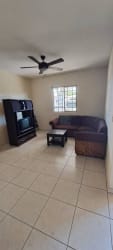 Living room area with ceiling fan, tiled floor and window in rental house David Chiriquí