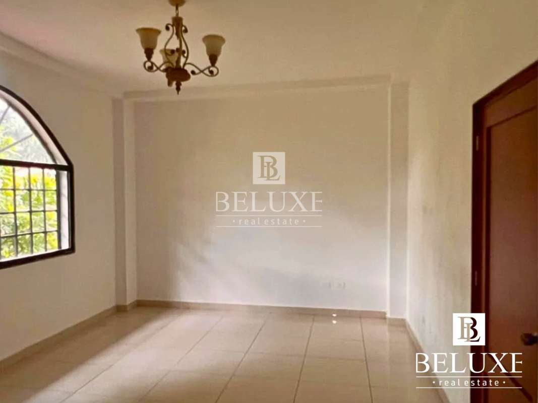 Spacious living room with tiled floor and arched dining entry in house Panama City