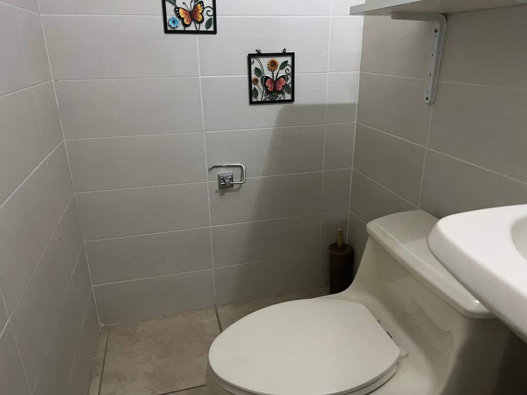 Modern kitchen with black cabinets, granite countertop, stainless appliances at PH Alpes in Brisas del Golf Panama City