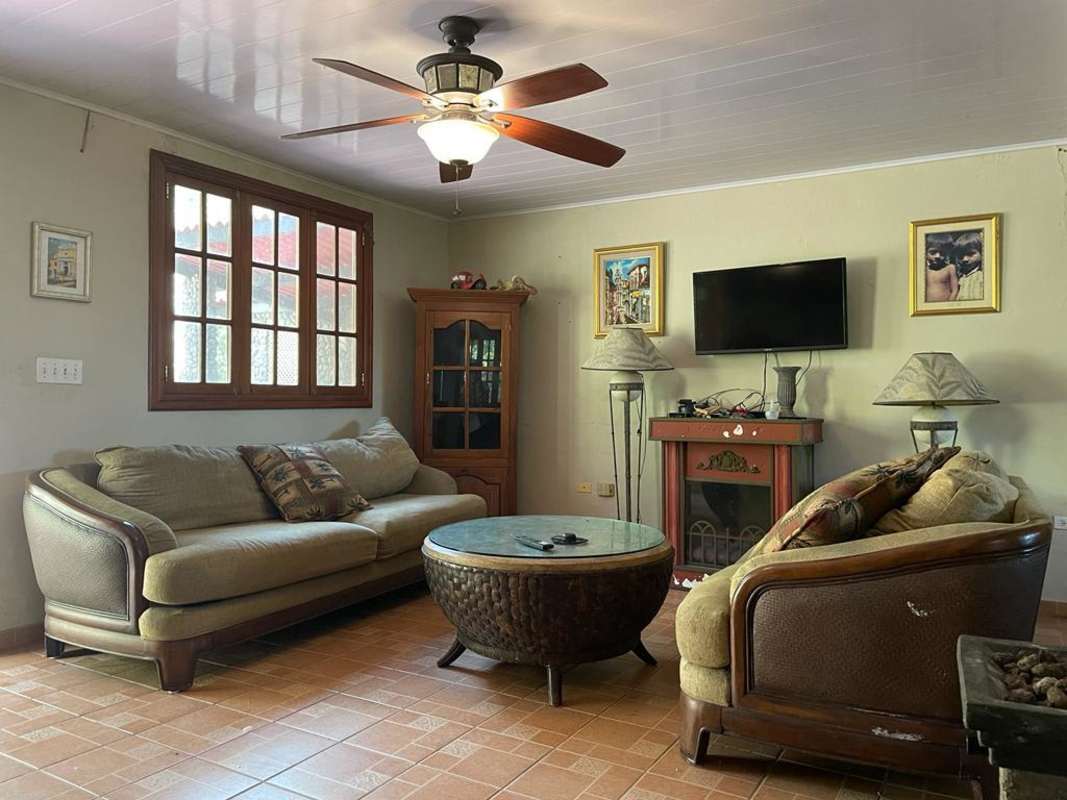 Rustic sunroom patio with stone wall and large windows forest view Altos de Cerro Azul Panama
