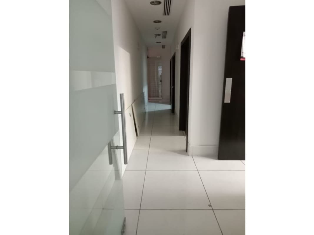 Empty office room with wooden floors and glass entry at Torres de las Americas