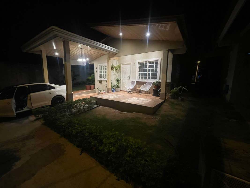 Covered porch and carport illuminated at night in PH Monte Bello house 24 de Diciembre Panama