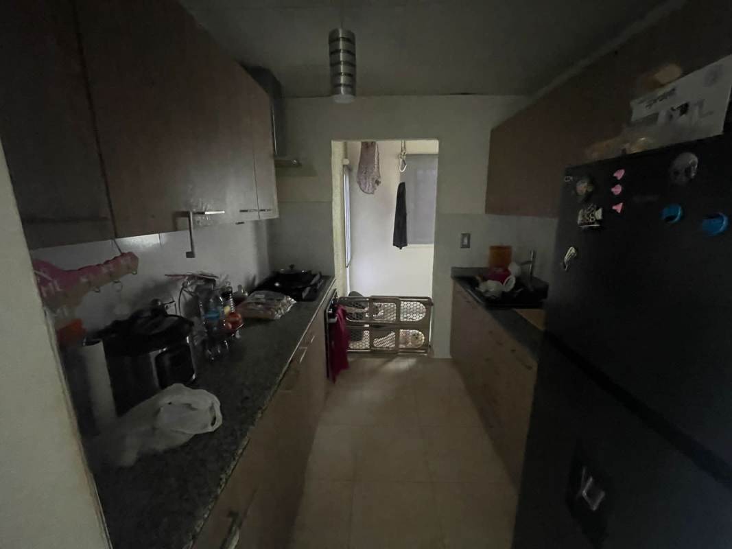 Galley kitchen with granite countertops, wood cabinetry, stove and refrigerator space PH Monte Bello Panama