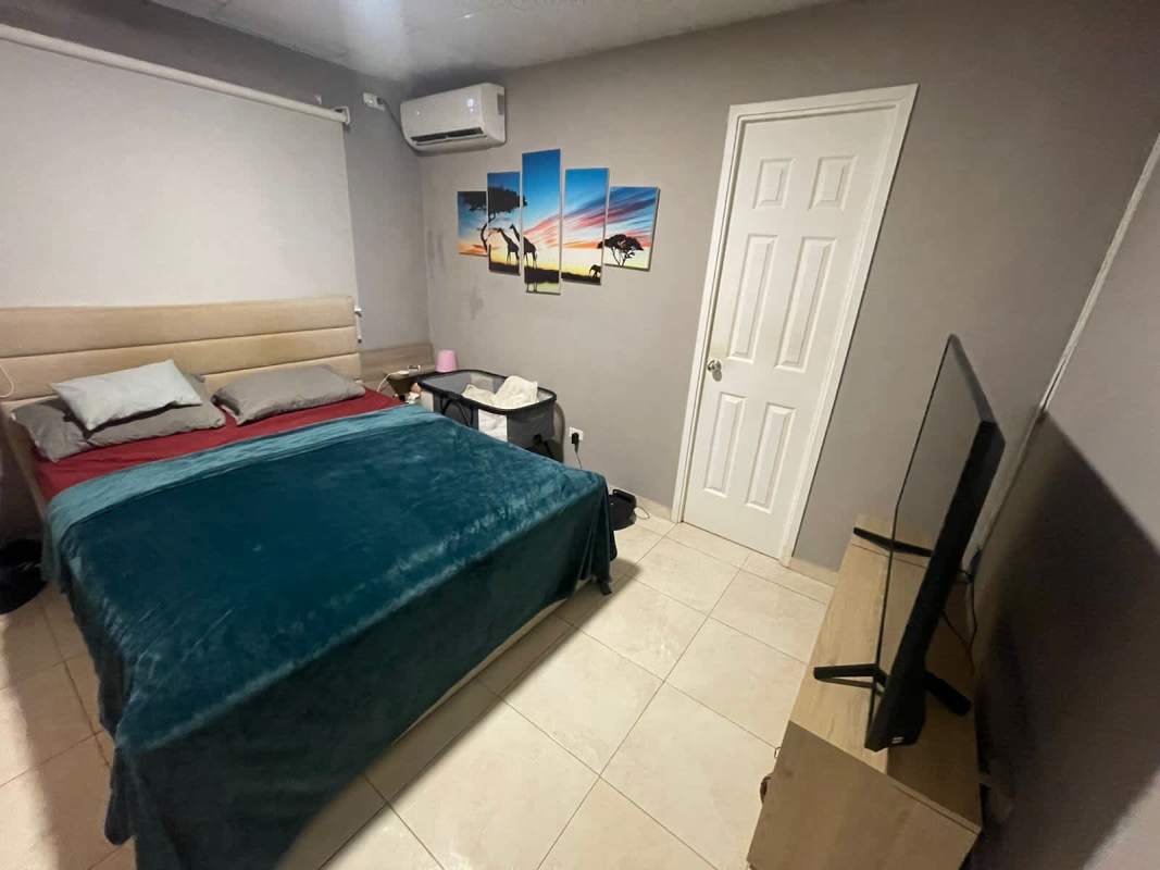Bedroom with large bed, wall AC, TV on stand, wall art PH Monte Bello 24 de Diciembre Panama