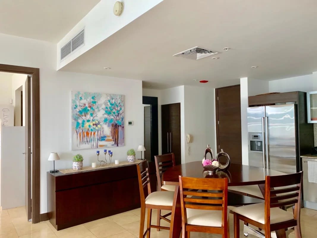 Contemporary dining area and chef's kitchen with appliances in The Ocean Club Punta Pacífica condo