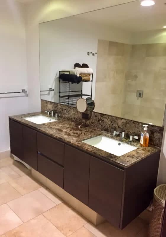 Spacious bathroom with double sink and glass shower at luxury condo The Ocean Club Panama