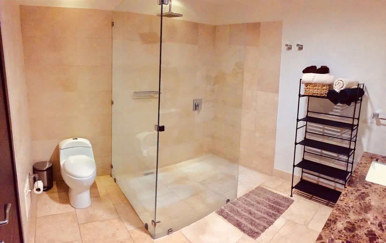 Modern bathroom featuring walk-in glass shower, granite countertop at The Ocean Club Panama