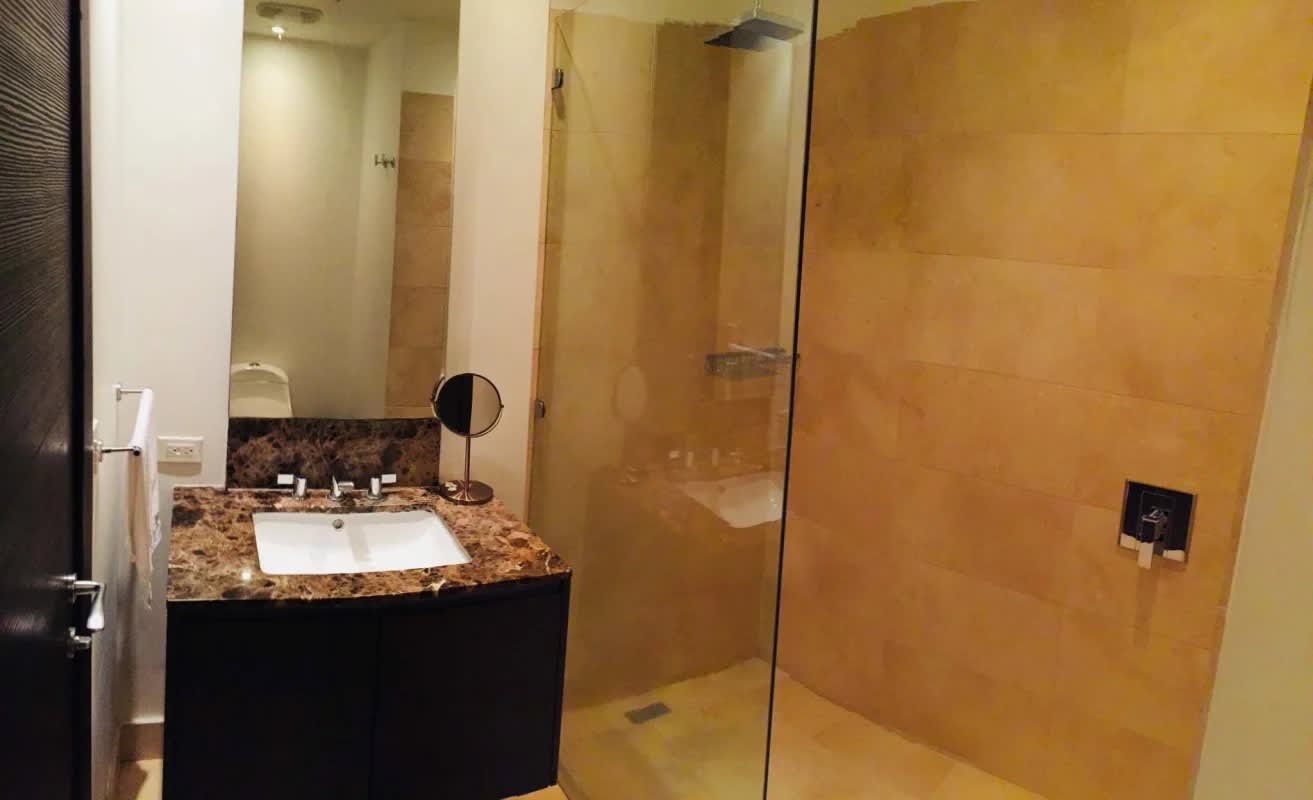 Contemporary bathroom with marble countertop and glass shower at The Ocean Club Panama