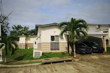 Single-family corner home with palm trees, carport and driveway in Playa Dorada Panama