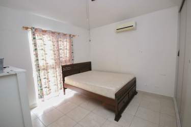 Bedroom with split AC, built-in closet and tile floor in Playa Dorada corner house for sale