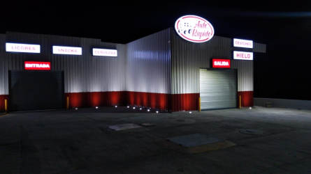 Night view secured commercial building roll-up shutters illuminated signage Penonomé Panama
