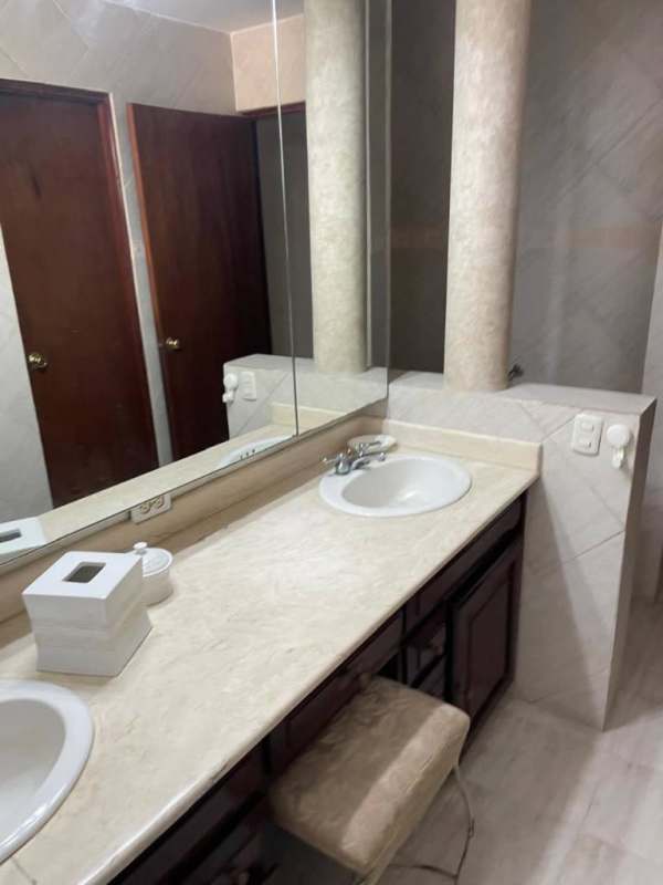 Bathroom with stone countertop, large mirror and modern fixtures at PH Vista Bella Plaza Marbella Panama City