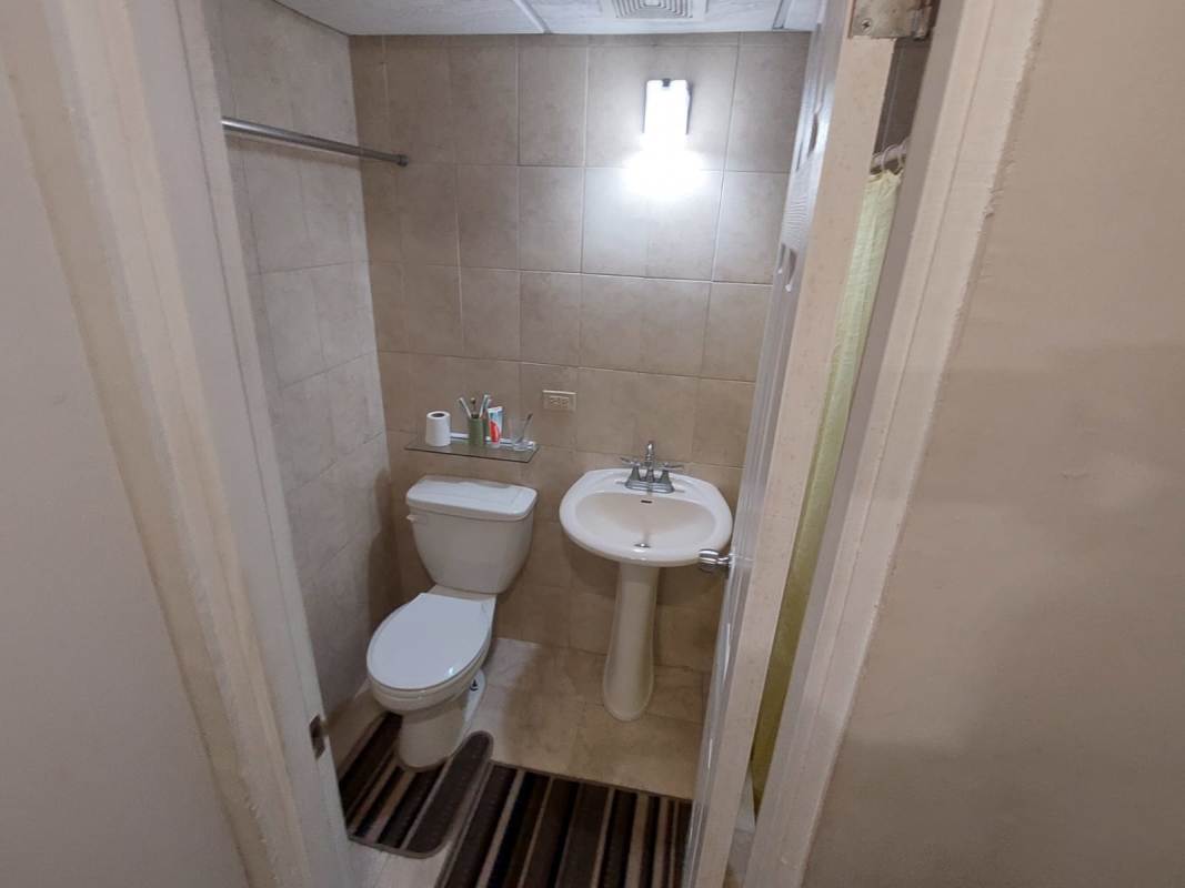 Galley kitchen with wood cabinets gas stove range hood and laundry area PH Girasoles Panama