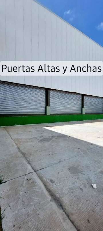 Modern warehouse exterior with wide rolling gates elevated loading bays concrete yard in Las Mañanitas Panama City