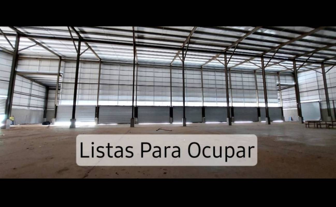 Spacious empty modern warehouse interior with concrete floors high ceilings roll-up doors in Panama