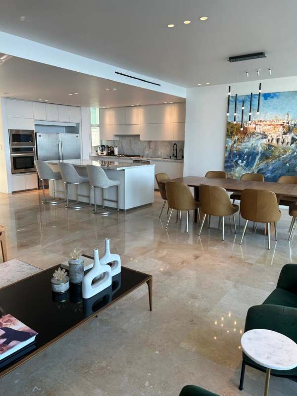 Modern open kitchen with marble floors, island, stainless appliances and dining space in PH Ocean Sky Coco del Mar Panama