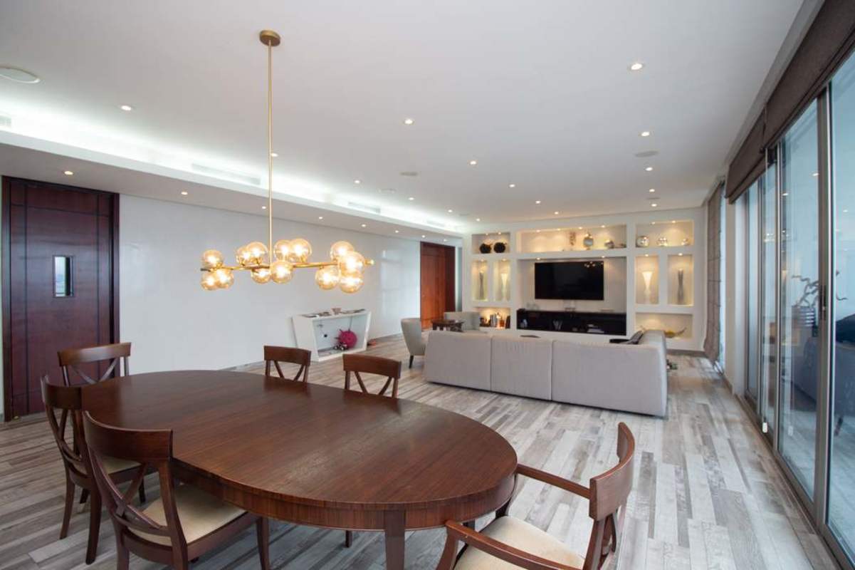 Contemporary open living and dining room with chandelier, city views at PH Aqualina Punta Pacifica