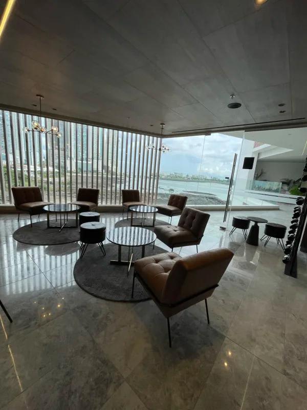 Luxurious common lounge with floor-to-ceiling windows overlooking marina in PH Ocean Front Panama City