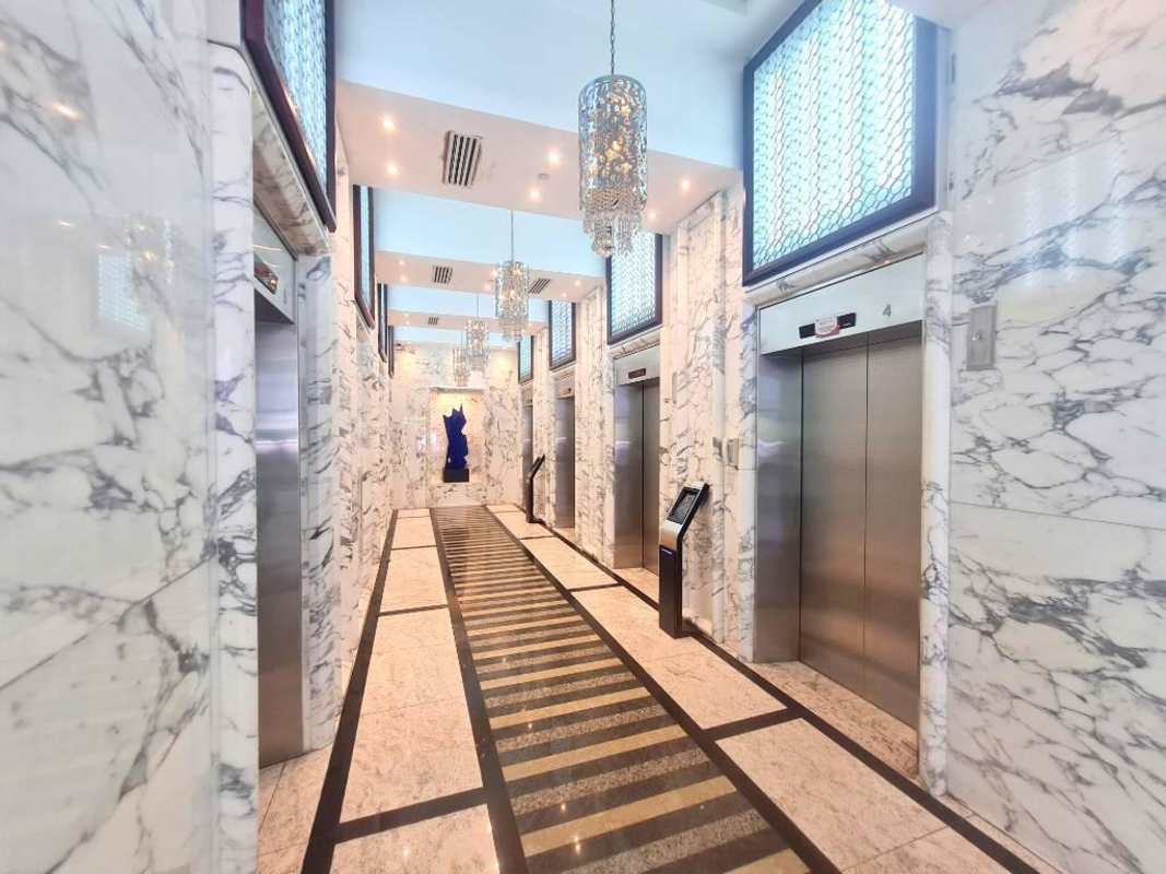 Elegant marble elevator lobby with chandeliers multiple elevators PH Revolution Tower Panama