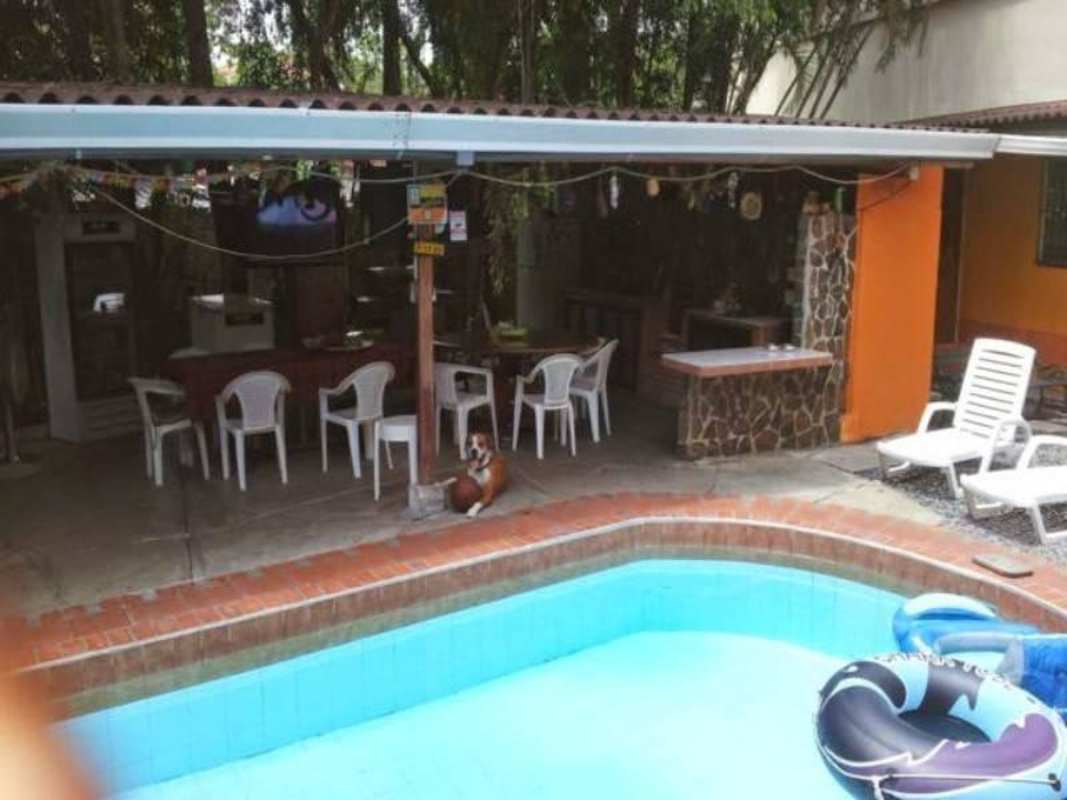 Backyard garden with swimming pool, bright house exteriors gravel walkway Panama City