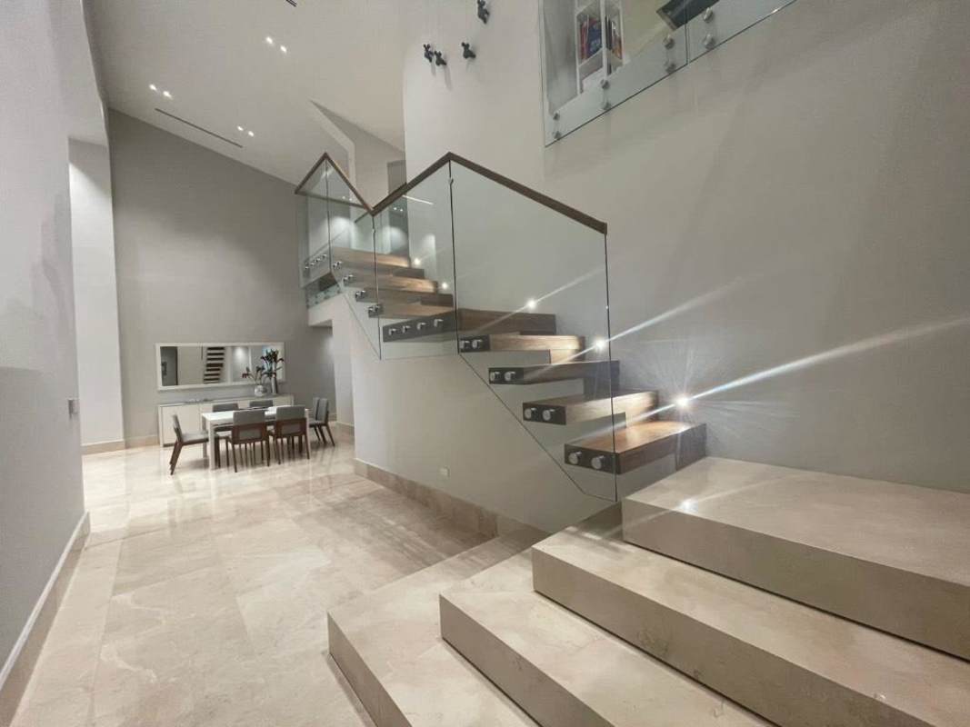 Modern empty living room with marble floors, floor-to-ceiling windows offering golf course views at Santa María The Reserve Panama