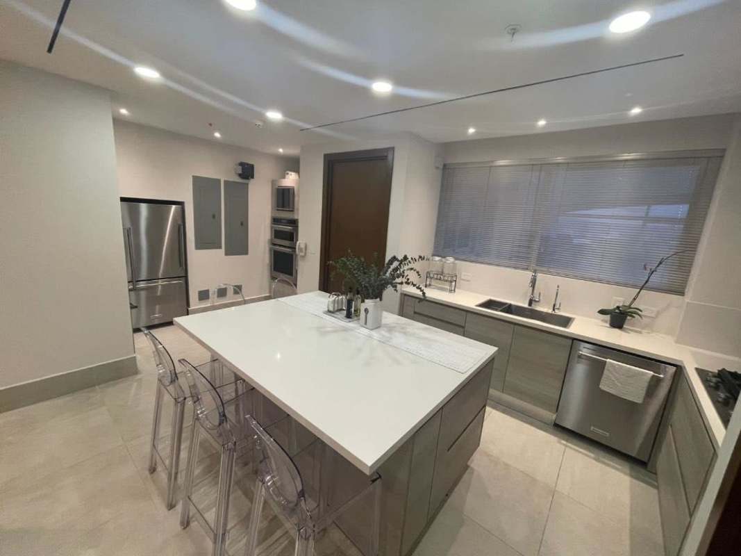 Elegant duplex with glass floating staircase, modern dining area and double-height ceiling at The Reserve Santa María Panama