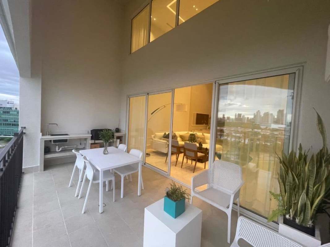 Contemporary living and dining space with tall ceilings, large windows, and luxury finishes in duplex apartment Santa María Panama