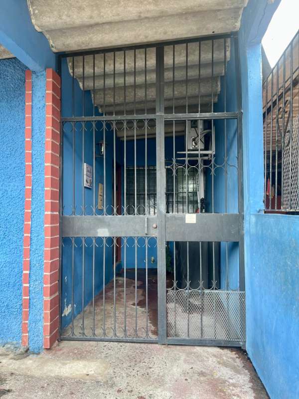 Main front entry with metal bars, blue walls, brick trim at Villa Venus Juan Díaz Panama