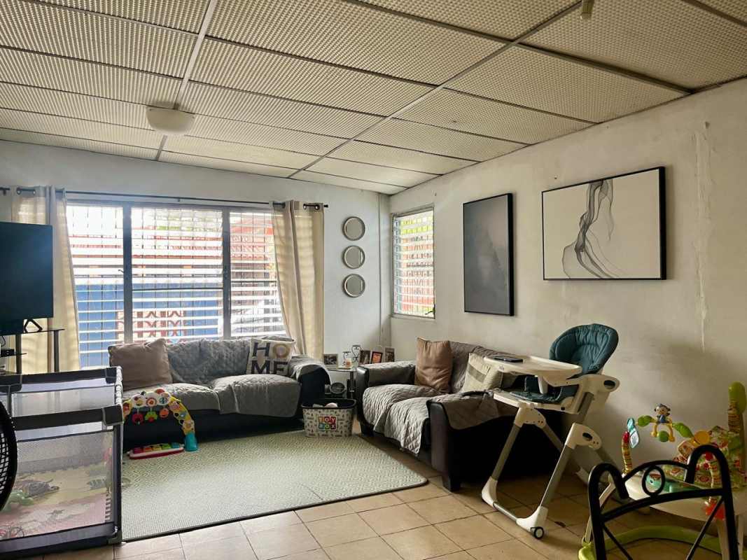 Living room with baby playpen couch and natural light Villa Venus Juan Díaz
